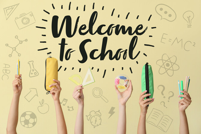 Hands of pupils with stationery and text WELCOME TO SCHOOL on color background