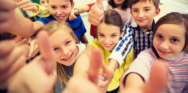 Group of children giving a thumbs up