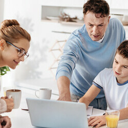 Caring family couple helping their son with homework