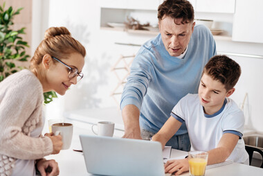 Caring family couple helping their son with homework