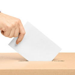 Man's hand inserting ballot into ballot box