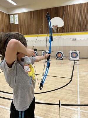 Young male student practicing archery